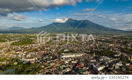 Aerial view of city of Bukittinggi and Mount Marapi. A clock tower Jam Gadang. Sumatra. Indonesia. Aerial view of city of Bukittinggi and Mount Marapi. A clock tower Jam Gadang. Sumatra. Indonesia. 133195274