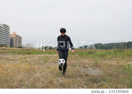 サッカーのリフティングの練習をする男性 133195668