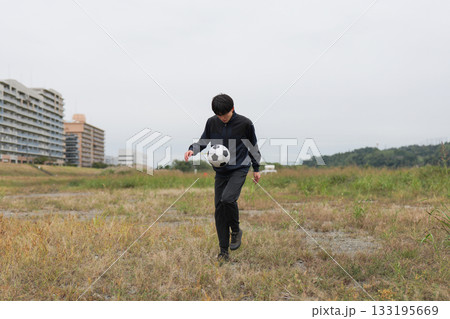 サッカーのリフティングの練習をする男性 133195669