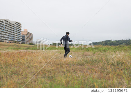 ドリブルの練習をするサッカー選手の後ろ姿 133195671