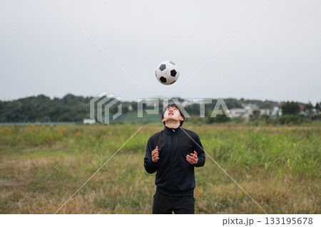 サッカーのヘディングの練習をする男性 133195678