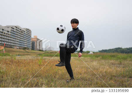 サッカーのリフティングの練習をする男性 133195690