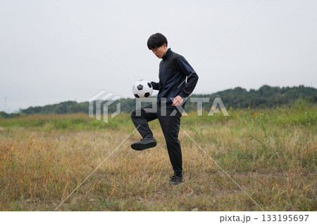 サッカーのリフティングの練習をする男性 133195697