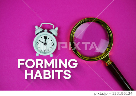 Alarm clock and a magnifying glass on a bright pink background, with text "Forming Habits" Alarm clock and a magnifying glass on a bright pink background, with text "Forming Habits" 133196124
