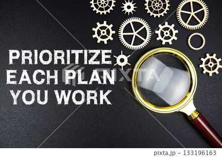 Prioritize Each Plan You Work text message on sticky note with magnifying glass on black background Prioritize Each Plan You Work text message on sticky note with magnifying glass on black background 133196163