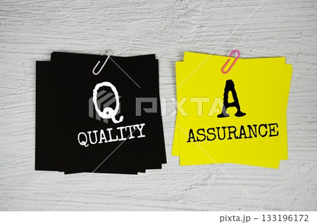 QA - Quality Assurance text on stick note on concrete background 133196172