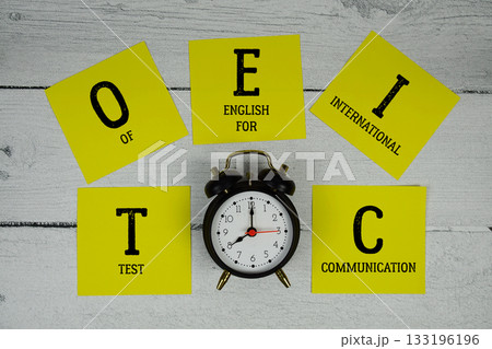 TOEIC Test of English for International Communication with alarm clock on wooden background TOEIC Test of English for International Communication with alarm clock on wooden background 133196196