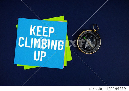 Keep Climbing Up text written on sticky note with compass on blue background Keep Climbing Up text written on sticky note with compass on blue background 133196639