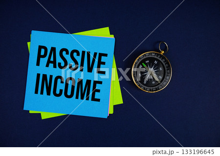 Passive Income text written on sticky note with compass on blue background Passive Income text written on sticky note with compass on blue background 133196645