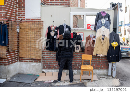 Person browsing jackets at an outdoor street market in Seoul, South Korea Person browsing jackets at an outdoor street market in Seoul, South Korea 133197091