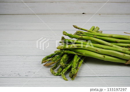 Bunch of fresh green asparagus stems on wooden background 133197297