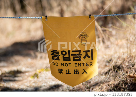 Yellow warning sign with Korean and English text Do Not Enter hanging on a rope outdoors in Seoul, South Korea Yellow warning sign with Korean and English text Do Not Enter hanging on a rope outdoors in Seoul, South Korea 133197353
