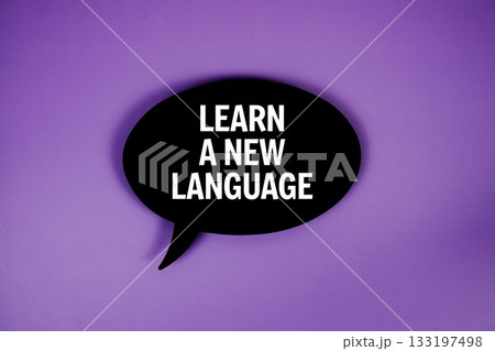 Learn A New Language text with speech bubble top view on purple background Learn A New Language text with speech bubble top view on purple background 133197498