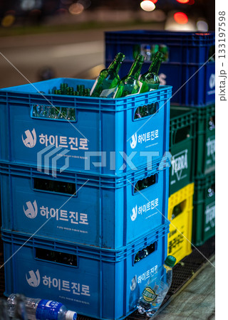 Blue crates filled with empty green beer glass bottles stacked on a street in Seoul, South Korea 133197598