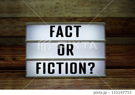 Lightbox with text "Fact Or Fiction?" on wooden background 133197753