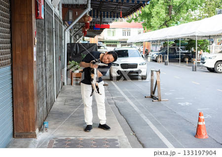 Gentle Encounter, a man carefully lifts a cat in his arms sharing a quiet moment of trust tenderness and connection between human and animal. 133197904
