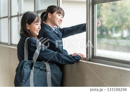 学校の廊下で会話する制服姿の中学生の女子生徒 学校の廊下で会話する制服姿の中学生の女子生徒 133198298
