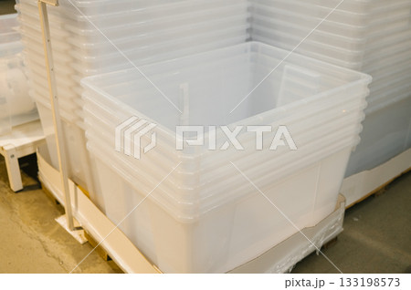 Stacked clear plastic storage bins on warehouse pallet 133198573