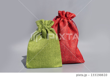 Two colorful fabric gift bags on gray background Two colorful fabric gift bags on gray background 133198610