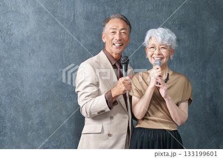 カラオケでマイクを持って歌うシニア男女 133199601