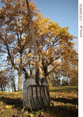 Garden Fork and Canisters in Autumn Landscape 133199938