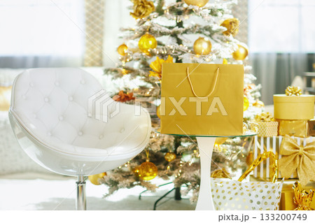 Golden Gifts and Christmas Tree in a Cozy Interior 133200749