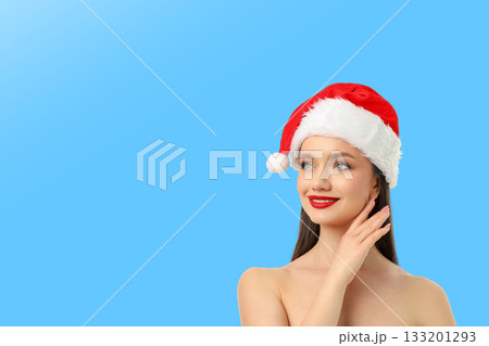 Model wearing Santa hat looking away with a smile Model wearing Santa hat looking away with a smile 133201293