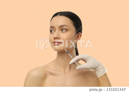 Professional administering cosmetic treatment to client 133201347