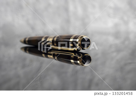 Fountain pen on a gray marble background. Boxed and unboxed. Selective focus. Fountain pen on a gray marble background. Boxed and unboxed. Selective focus. 133201458