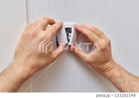 male hands of electrician installing electric light switch at home. Replacing. 133202149