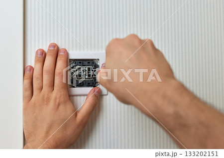 electrician installing electric light switch using screwdriver at home, close-up 133202151