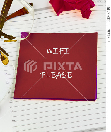 A red card stating WIFI PLEASE sits atop a lined notebook, near glasses and a red tissue. It looks like someone needs to connect to the internet A red card stating WIFI PLEASE sits atop a lined notebook, near glasses and a red tissue. It looks like someone needs to connect to the internet 133202396