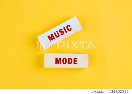 Bright yellow blocks display the words music mode, inviting a sense of joy and enthusiasm. These vibrant letters suggest a celebration of sound and rhythm, perfect for inspiration Bright yellow blocks display the words music mode, inviting a sense of joy and enthusiasm. These vibrant letters suggest a celebration of sound and rhythm, perfect for inspiration 133202533