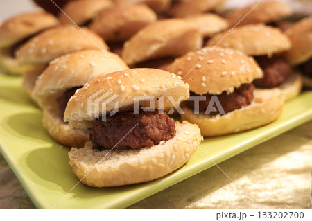 Tray of mini beef burgers in sesame buns Tray of mini beef burgers in sesame buns 133202700