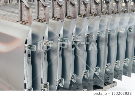 batch of unpainted metal car doors ready for car assembly in the welding shop of car assembly plant 133202928