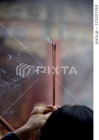 Woman burning incense and praying in Yonghe Temple of Tibetan Buddhism in Dongcheng District in Beijing, China 133203569