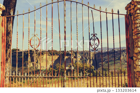 Old gate and Ronda town in distance, Spain. 133203614