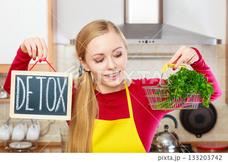 Woman holding detox sign and shopping basket with 133203742