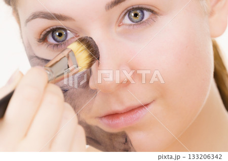 Woman being apply black carbo mask to face Woman being apply black carbo mask to face 133206342