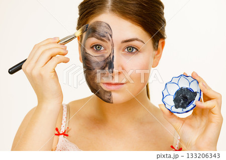 Woman being apply black carbo mask to face Woman being apply black carbo mask to face 133206343