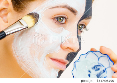 Girl black mask on half face apply white mud 133206350