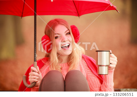 Girl in autumn park enjoying hot drink 133206551