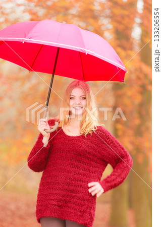 Fashion woman with umbrella relaxing in fall park. 133206554