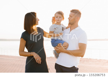 Family Enjoying Quality Time Outdoors At Sunset By Waterfront 133206753