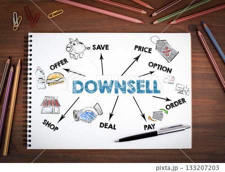 DOWNSELL, Business Concept. Notebooks, pen and colored pencils on a wooden table 133207203