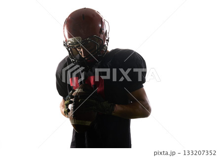 Football player holding ball closely with emotional concentration 133207352