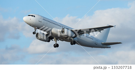 Airplane take off on the blue sky, with white clouds. Aircraft flying on sky background. White passenger jet plane in the blue sky. Low angle view of Airplane flying under blue sky, with white clouds 133207718