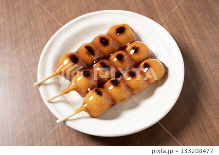 白い皿にのったみたらし団子 133208477