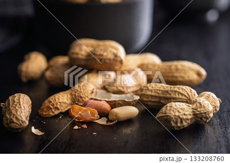Peanuts in shell. Groundnuts on black table. 133208760