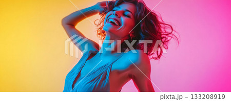 Woman with open arms, enjoying vibrant neon lights 133208919